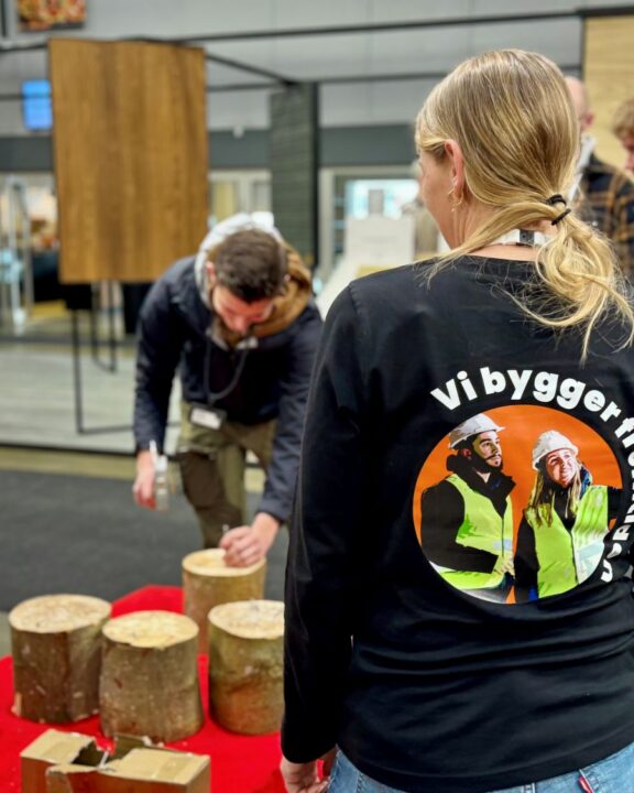 KF repræsentant i forgrunden. Der slås søm i I baggrunden