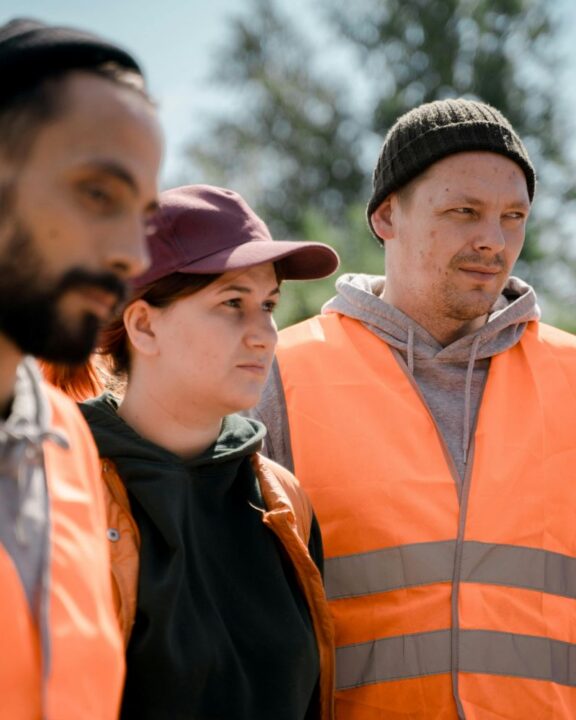 Tre bygningskonstruktørende iført orange vest