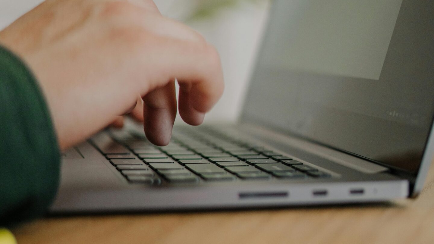 Hænder ved en laptops tastatur
