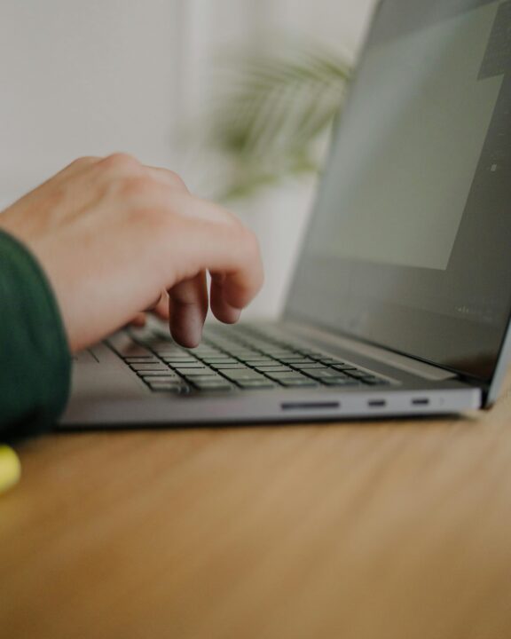 Hænder ved en laptops tastatur